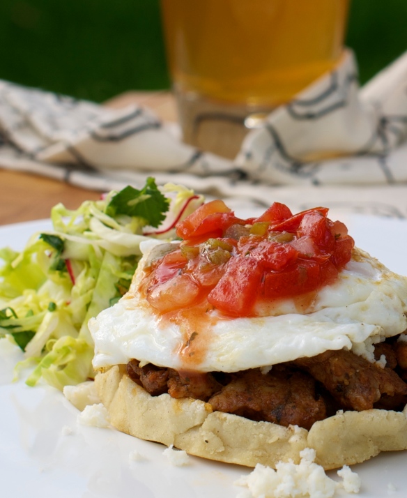 Breakfast Sopes topped with chorizo, a fried egg and salsa